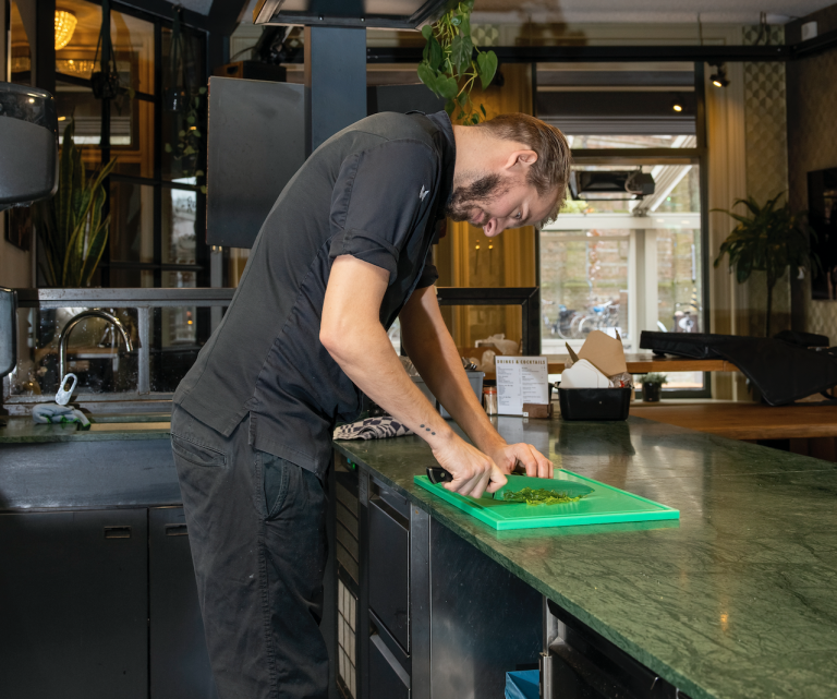 voorover gebogen chef rugpijn in keuken